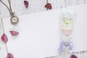 weiß lackiertes Holz Tischpapier Blütenblätter Zuckerwatte Taschenuhr foto