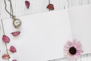 Papier mit Uhr, Blume und Blütenblättern foto