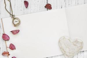 weiß lackierter Holztisch lila Blütenblätter Taschenuhr Herz Handwerk foto