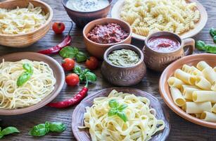 Pasta mit anders Arten von Soße auf das hölzern Hintergrund foto