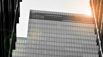 Glas modern Gebäude mit Blau Himmel Hintergrund. Aussicht und die Architektur Einzelheiten. städtisch abstrakt - - Fenster von Glas Büro Gebäude im Sonnenlicht Tag. schwarz und Weiß. foto