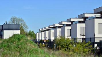 Vorort- Gegend mit Eigentumswohnung Komplex. Vorort- Bereich mit modern geometrisch Familie Häuser. Reihe von Familie Häuser gegen Blau Himmel. foto