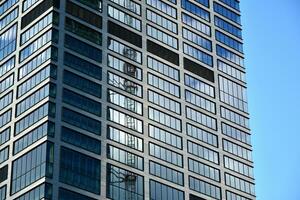 modern Büro Gebäude mit Glas Fassade auf ein klar Himmel Hintergrund. transparent Glas Mauer von Büro Gebäude. foto