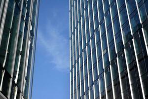 Glas Gebäude mit transparent Fassade von das Gebäude und Blau Himmel. strukturell Glas Mauer reflektieren Blau Himmel. abstrakt modern die Architektur Fragment. zeitgenössisch architektonisch Hintergrund. foto