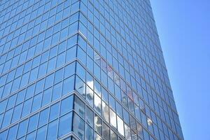 Glas Gebäude mit transparent Fassade von das Gebäude und Blau Himmel. strukturell Glas Mauer reflektieren Blau Himmel. abstrakt modern die Architektur Fragment. zeitgenössisch architektonisch Hintergrund. foto