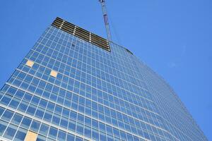 Glas Gebäude mit transparent Fassade von das Gebäude und Blau Himmel. strukturell Glas Mauer reflektieren Blau Himmel. abstrakt modern die Architektur Fragment. zeitgenössisch architektonisch Hintergrund. foto