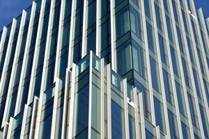 Glas Gebäude mit transparent Fassade von das Gebäude und Blau Himmel. strukturell Glas Mauer reflektieren Blau Himmel. abstrakt modern die Architektur Fragment. zeitgenössisch architektonisch Hintergrund. foto