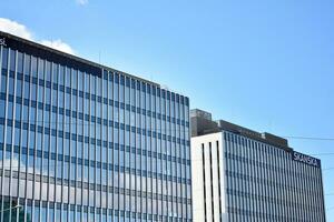 modern Büro Gebäude im das Stadt mit Fenster und Stahl und Aluminium Paneele Mauer. zeitgenössisch kommerziell die Architektur, Vertikale konvergieren geometrisch Linien. foto