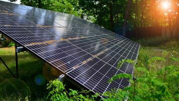 Solar- Paneele mit ein groß Oberfläche. Photovoltaik Paneele Stehen auf ein gepflastert Oberfläche gegen das Hintergrund von Bäume und Gebüsch. foto