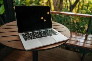 Laptop auf dem Tisch im Garten foto