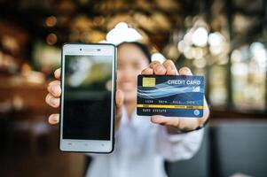 Smartphone und Kreditkarte mit weiblicher Hand foto