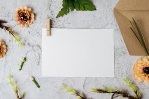 eine leere Karte mit Umschlag und Blume wird auf weißem Hintergrund platziert foto