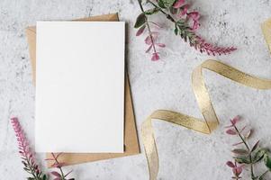 eine leere Karte mit Umschlag und Blume wird auf weißem Hintergrund platziert
