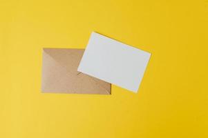 eine leere Karte mit Umschlag wird auf gelben Hintergrund gelegt foto