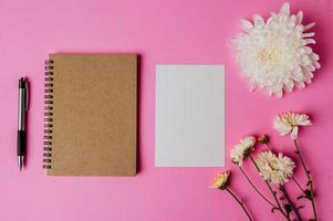 Notizbuch mit Blume auf rosa Hintergrund foto