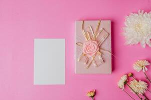 rosa Geschenkbox, Blume und leere Karte auf rosa Hintergrund foto