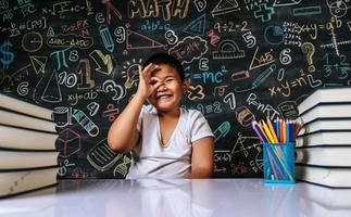 Kind sitzt und lächelt im Klassenzimmer
