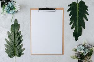 Notizpapier auf einem Stück Holz mit Blättern und Blumen foto