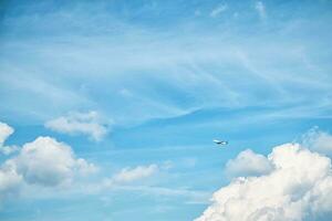 ein Weiß Flugzeug im das Himmel mit schön Weiß Wolken. reisen, Flug, Freiheit foto