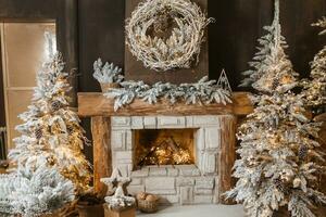 das Innere von ein Zimmer mit ein Kamin, Weihnachten Bäume mit künstlich Schnee und Girlanden, ein Decke und ein Tablett mit heiß Getränke. das magisch Atmosphäre von Weihnachten. foto