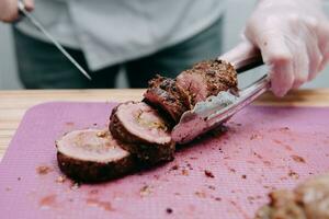 Kochen Fleisch Rollen im das Kochen Klasse. Rindfleisch rollen mit Gewürze. das Prozess von Schneiden ein rollen, Nahansicht. foto