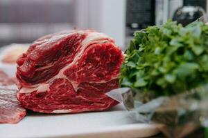 alt Rindfleisch zum Kochen Steak im ein Kochen Klasse. roh Rindfleisch und grüne, Nahansicht. foto
