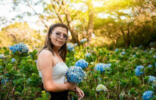 lächelnd Frau im ein Hortensie Feld. Porträt von jung Frau im ein Hortensie Garten, schön Mädchen im ein natürlich Blume Kindergarten. el Crucero - - Managua, Nicaragua foto