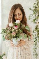 ein braunhaarig Frau mit lange Haar ist haben Frühstück im ein schön Blumen- Standort. Frühling Porträt. foto