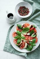 Caprese-Salat mit Tomaten, Mozzarella und Basilikum. foto