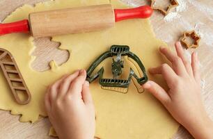 Kinder- Hände mit Lebkuchen Kekse auf hölzern Hintergrund foto