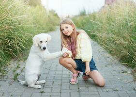 Hündchen Labrador Retriever und wenig Mädchen foto