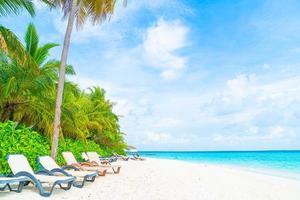 Strandkorb mit tropischer Hotelinsel auf den Malediven und Meer foto