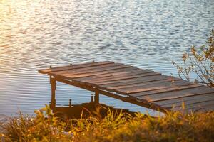 hölzern Seebrücke auf das Fluss. Herbst, Sonnenuntergang foto