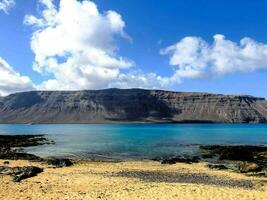 ein Strand mit ein Gelb Berg im das Hintergrund foto