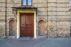 hölzern Türen zu ein alt Backstein Gebäude foto