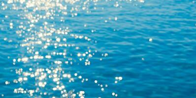 schön verschwommen natürlich Blau Hintergrund mit Highlights auf das Wasser. das Konzept von Sommer- Ferien beim Meer. ai generativ foto