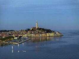 Drohne Bild von das historisch kroatisch Küsten Stadt, Dorf von rovinj während Sonnenaufgang foto