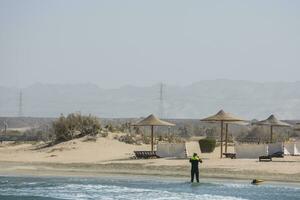 Mann mit Neoprenanzug und Schnorcheln Ausrüstung auf das Strand und rot Meer foto