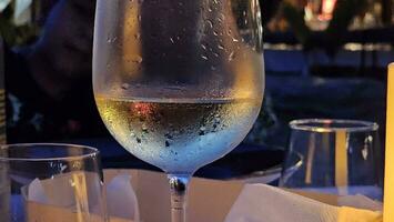 Glas von Weiß Wein serviert mit ein gekühlt Glas im ein Restaurant auf das ligurisch Riviera im Sommer- im 2023 foto