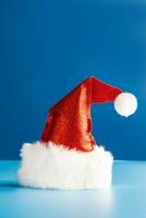 rot Santa claus Hut auf Blau Hintergrund. festlich Weihnachten oder Neu Jahr Konzept. Attrappe, Lehrmodell, Simulation foto