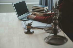 geschäftsleute und anwälte diskutieren vertragspapiere mit messingwaage auf dem schreibtisch im büro. gesetz, juristische dienstleistungen, beratung, justiz und gesetz konzeptbild mit filmkorneffekt foto