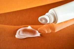 hygienisch feuchtigkeitsspendend Lippe Balsam im ein Tube auf ein Orange Hintergrund. foto
