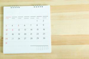 Kalender auf dem Tisch aus Holz. leerer kopierraum für text. konzept für beschäftigte zeitachse organisieren zeitplan, termin und erinnerung an treffen. planung für geschäftstreffen oder reiseplanungskonzept. foto