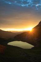 Sonnenaufgang am kleinen Bergsee in den Alpen foto