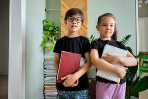 ein Junge und ein Mädchen mit Bücher im ihr Hände. foto