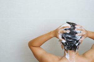 ein Mann ist Waschen seine Haar mit Shampoo foto