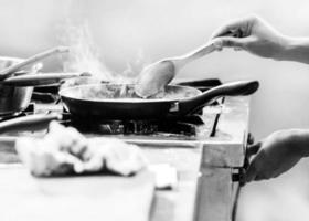 Koch bereitet Essen zu, Koch kocht in einer Küche, Koch bei der Arbeit foto