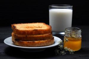 Toast auf einem Teller mit Milch und einer Dose Honig foto