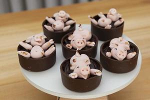 glückliche süße rosa schweine bonbons, die im schlamm spielen foto