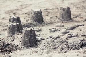 Sandburgen am Strand von Kindern gemacht foto